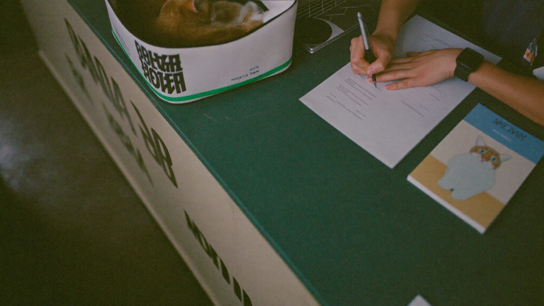 Hands stamping a form at a veterinary clinic reception desk